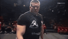 a man wearing a black shirt with the word forgotten on it
