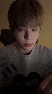 a young man wearing a white shirt that says " my " on the front