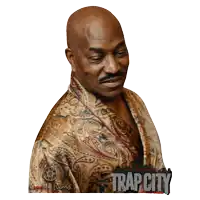 a man wearing a paisley robe with trap city written on the front