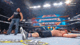 a man laying on the ground in a wrestling ring with a peacock logo on the bottom