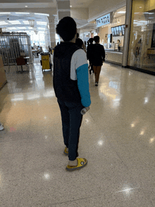 a person walking in a mall with a sign that says pan pizza on it