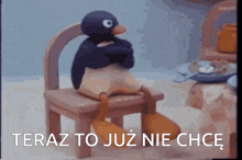 a stuffed penguin is sitting on a chair with the words teraz to już nie chce written below it