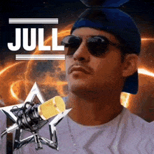 a man wearing sunglasses and a blue hat is standing in front of a microphone with the word jull written on it