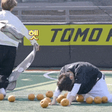 a man is kneeling down in front of a tomo sign
