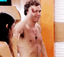 a shirtless man is giving a thumbs up while a woman looks on