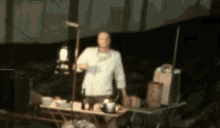 a blurry picture of a man standing next to a table