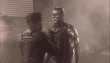 a man in a leather jacket is standing next to a statue of a man