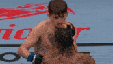 a man with a tattoo on his chest is being punched in the face