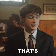 a man in a suit and tie says " that 's " in front of him