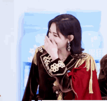 a woman covering her mouth with her hand in front of a blue container with chinese writing