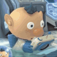 a close up of a stuffed animal holding a remote control