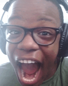 a young man wearing glasses and headphones with his mouth open