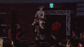 a referee is standing in a boxing ring with a crowd watching