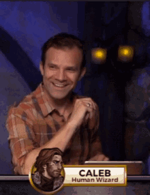 a man with a name tag that says caleb human wizard is smiling