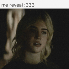 a woman in a dark room with the words me reveal 333 below her