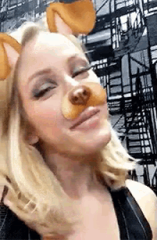 a woman is wearing a dog mask on her face and making a funny face .