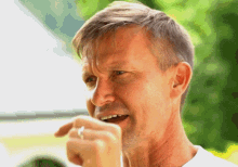 a man with a ring on his finger laughs