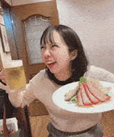 a woman holding a glass of beer and a plate of meat