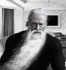 a black and white photo of an older man with a long beard .