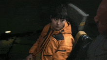 a woman wearing an orange jacket that says lenovo