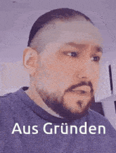 a man with a beard is wearing a blue shirt that says aus gründen on the front