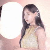 a woman in a yellow dress with a flower in her ear