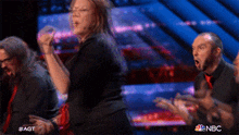 a group of people are dancing on a stage with nbc written on the bottom