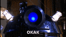 a close up of a robot 's head with the word okak on the bottom