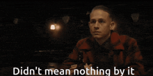 a man in a red jacket is holding a bottle of beer and says did n't mean nothing by it