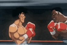 two men are boxing in a ring and one is wearing red boxing gloves .