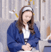 a woman wearing a blue hoodie with wb on the front