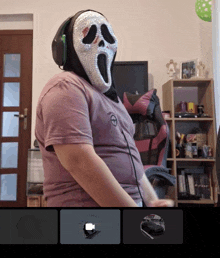 a man wearing a scream mask with headphones on