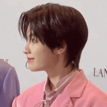 a close up of a person wearing a pink jacket and a pink shirt