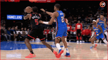 a basketball player with the number 5 on his back dribbles the ball