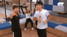a group of people are dancing in a room with a guitar in the background .
