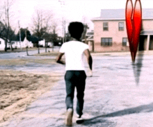 a man in a white shirt is walking down a road