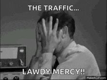 a man in a suit and tie is covering his face with his hands and says `` the traffic ... lawdy mercy ! ''