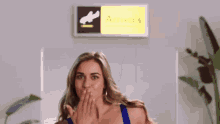 a woman blows a kiss in front of a arrivals sign