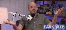a man is sitting in front of a microphone with the words dark web written on the bottom