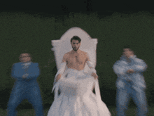 a man in a wedding dress sits on a throne