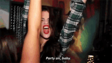 a woman in a plaid shirt is dancing with her arms in the air and says party on , baby .