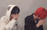 two men with red hair are covering their faces