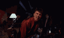 a blurry picture of a man in a red jacket dancing