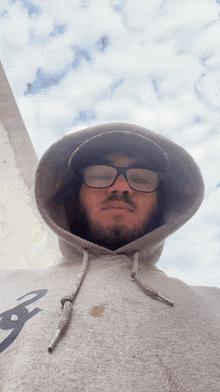 a man wearing glasses and a hooded sweatshirt with the letter f on the front