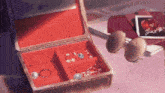 a red jewelry box filled with jewelry and sunglasses