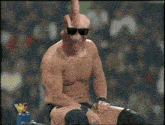 a shirtless wrestler is sitting in front of a sign that says wcf