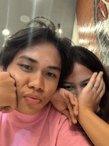 a man in a pink shirt and a woman in a pink shirt are posing for a picture