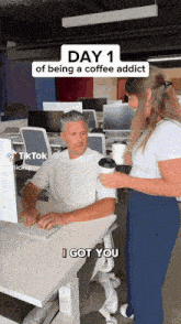 a man sitting at a desk with a cup of coffee and a woman standing next to him