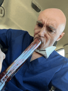 a man in a blue scrub top is smoking a pipe