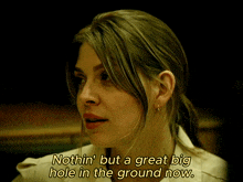 a woman says " nothin ' but a great big hole in the ground now " in a dark room
